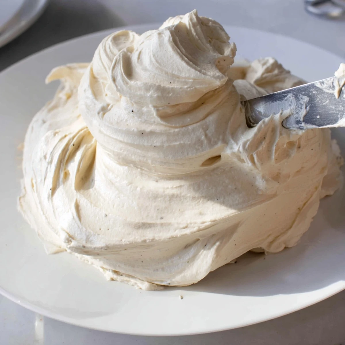Silky Italian meringue buttercream spread smoothly over freshly baked chocolate cupcakes