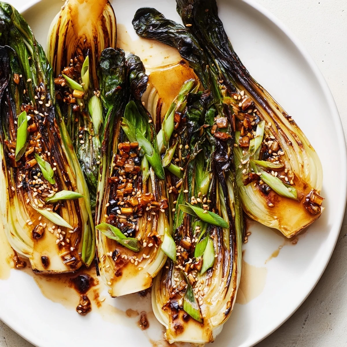 Tender caramelized garlic bok choy glistening with sesame soy glaze and green onions