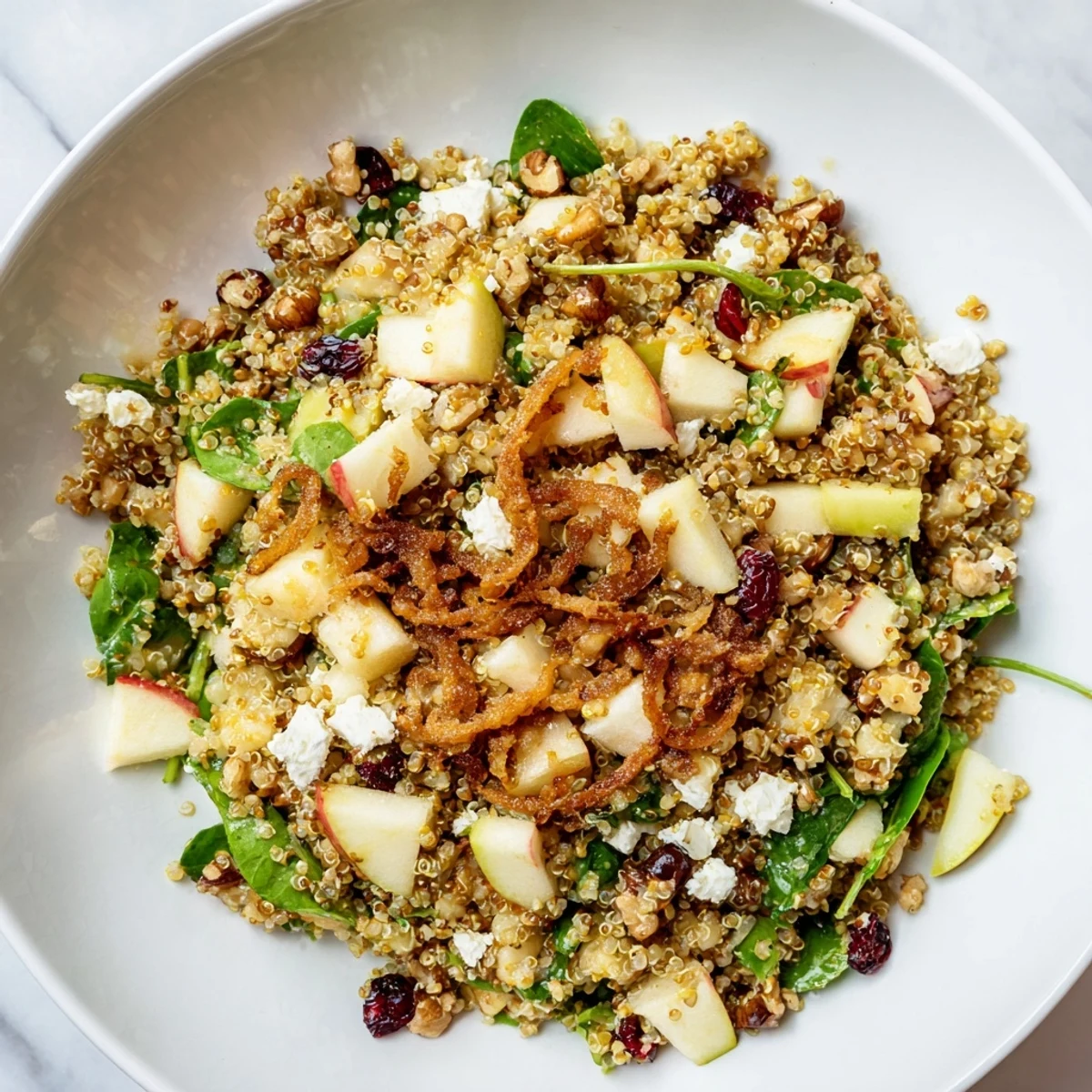 A close-up of Honey Mustard Quinoa Apple Salad with vibrant greens and dried cranberries