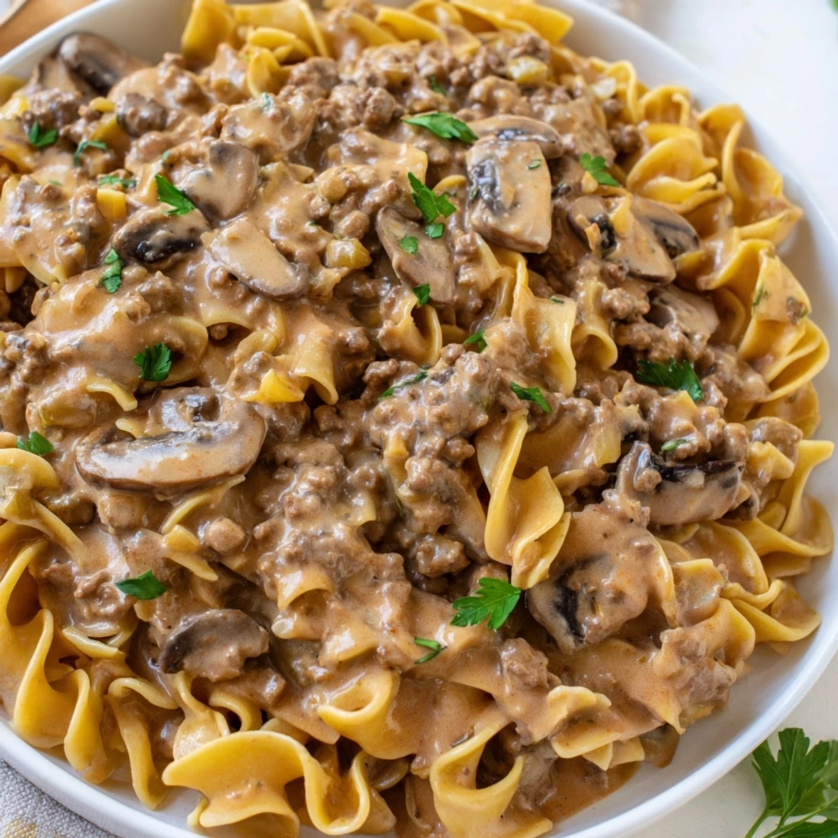 Hearty hamburger stroganoff topped with fresh parsley in a warm creamy skillet
