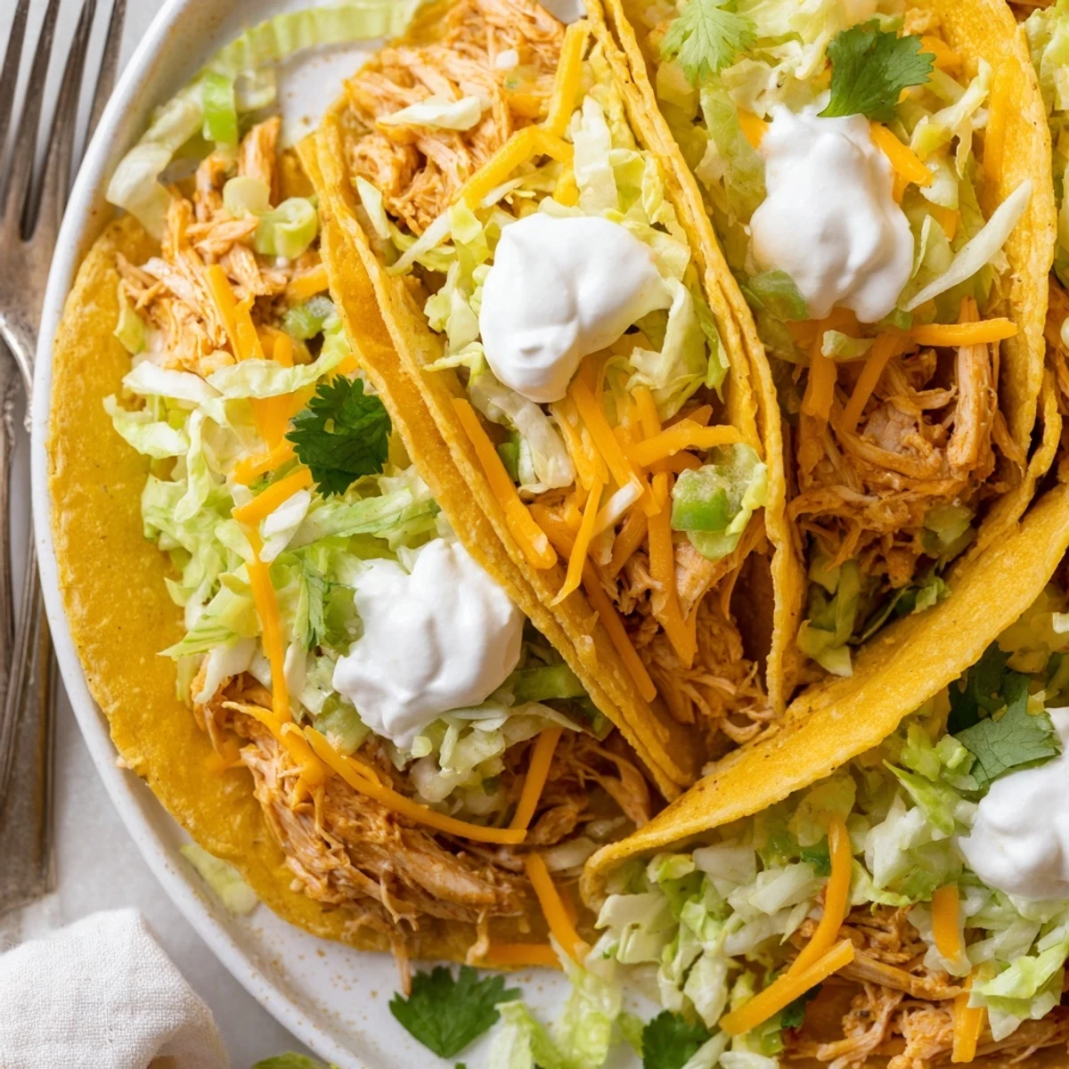 Juicy slow cooker ranch chicken tacos topped with melted cheese and fresh cilantro
