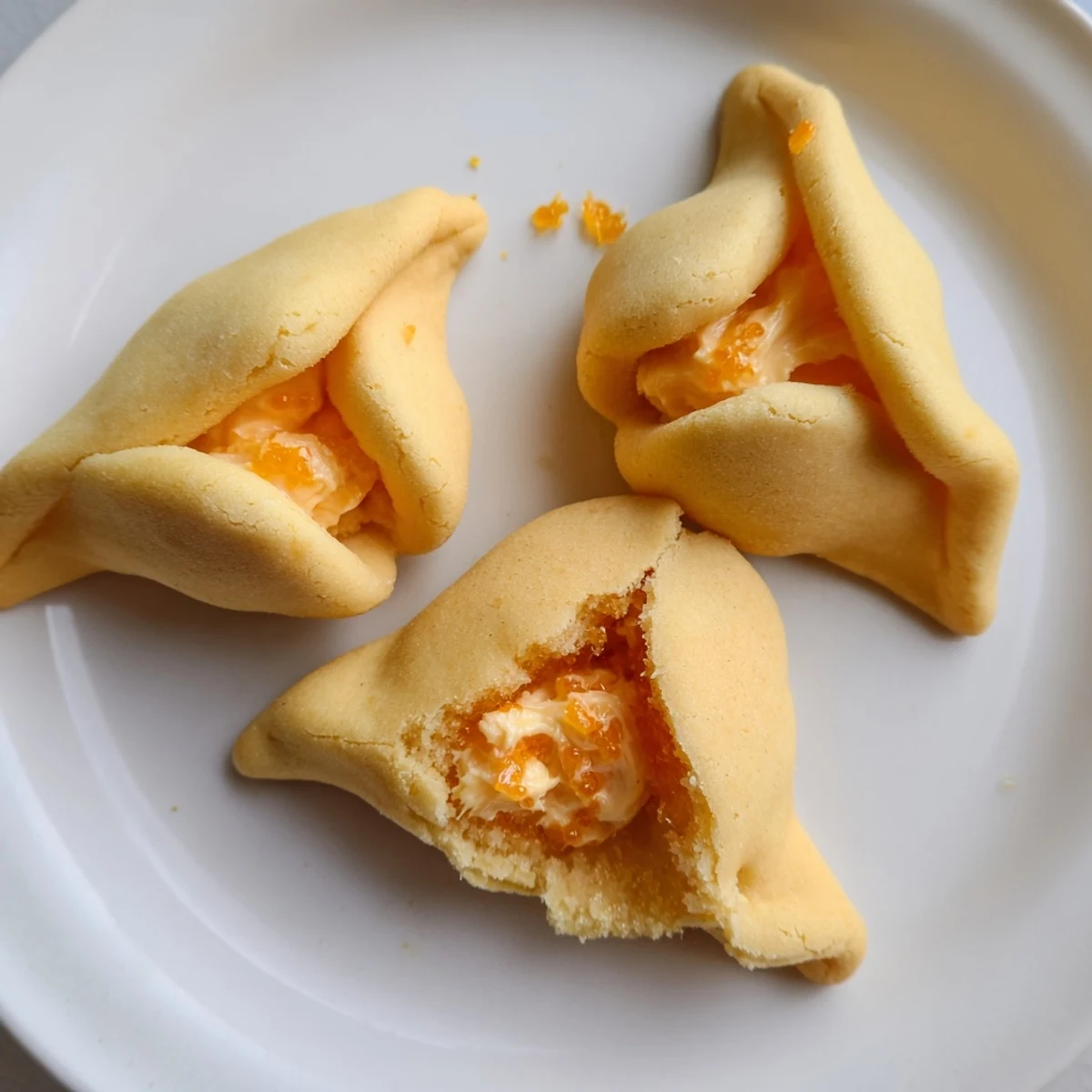 Golden Creamsicle Hamentaschen fresh from the oven with creamy orange filling