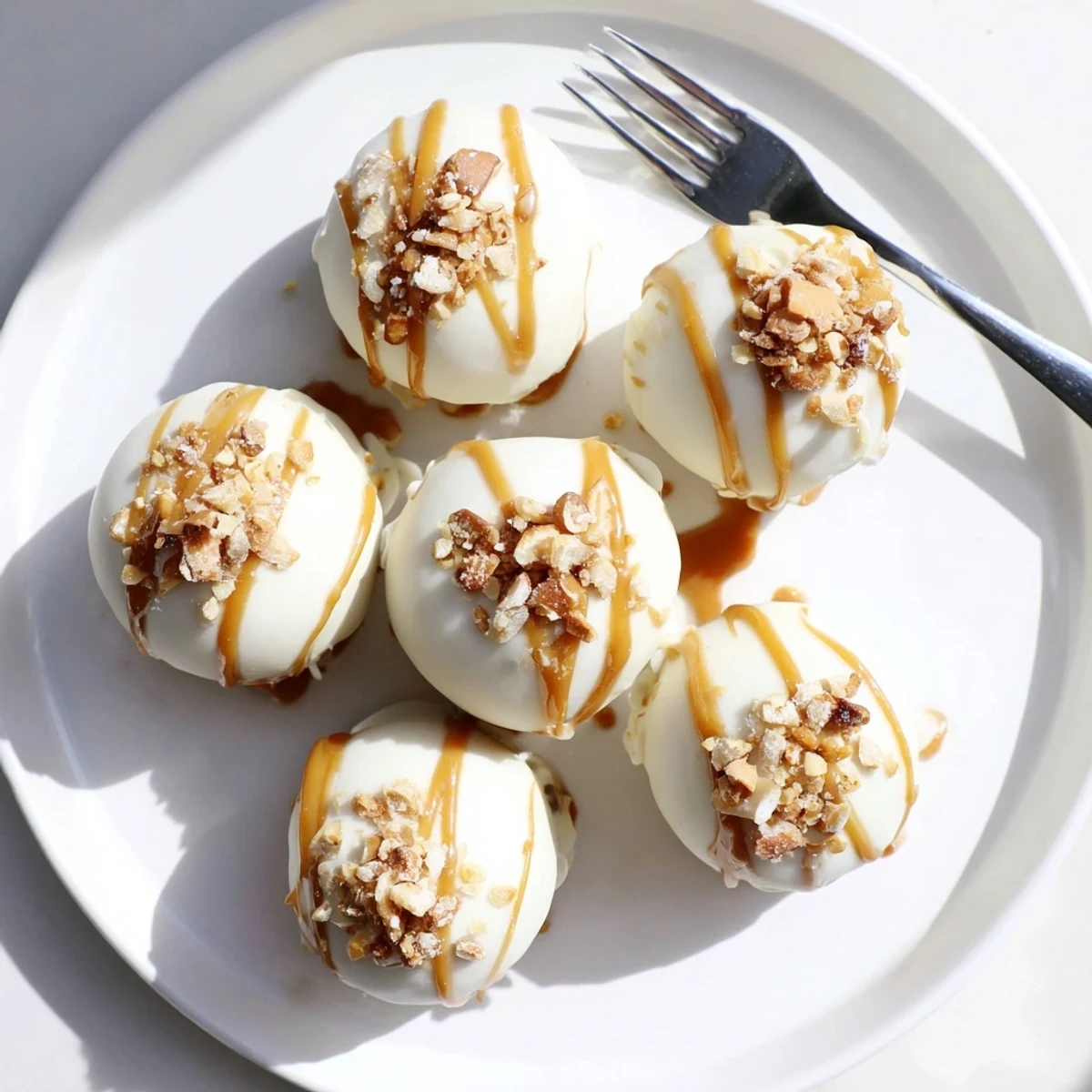 Golden-dipped salted caramel pretzel cheesecake balls coated in crunchy crushed pretzels with flaky salt