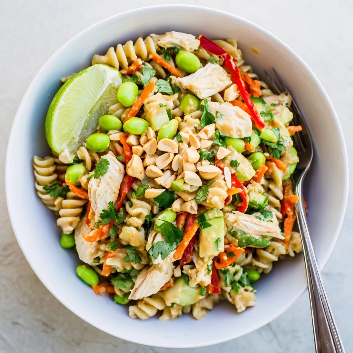 Colorful Protein Packed Thai Pasta Salad in a bowl with creamy peanut dressing