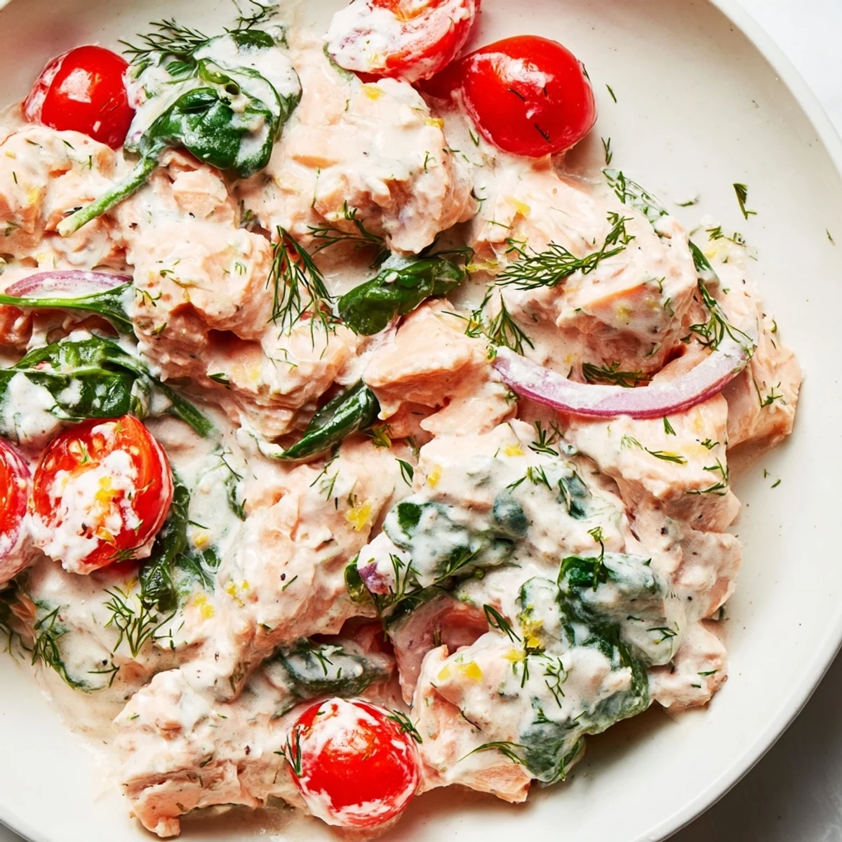 Healthy creamy leftover salmon recipe topped with fresh chives and served in a white bowl
