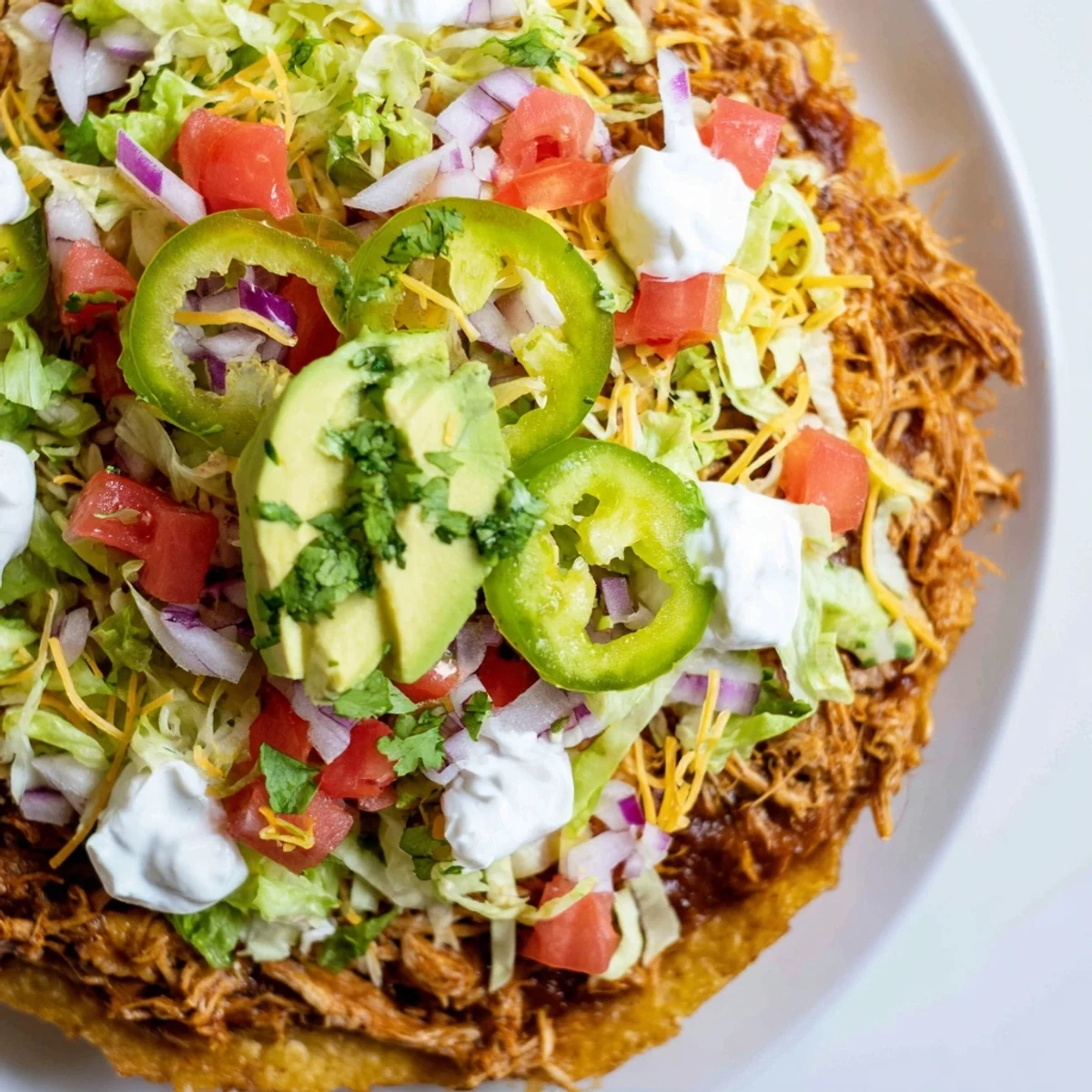 Delicious chicken tostadas featuring seasoned meat, beans, and colorful Mexican garnishes.