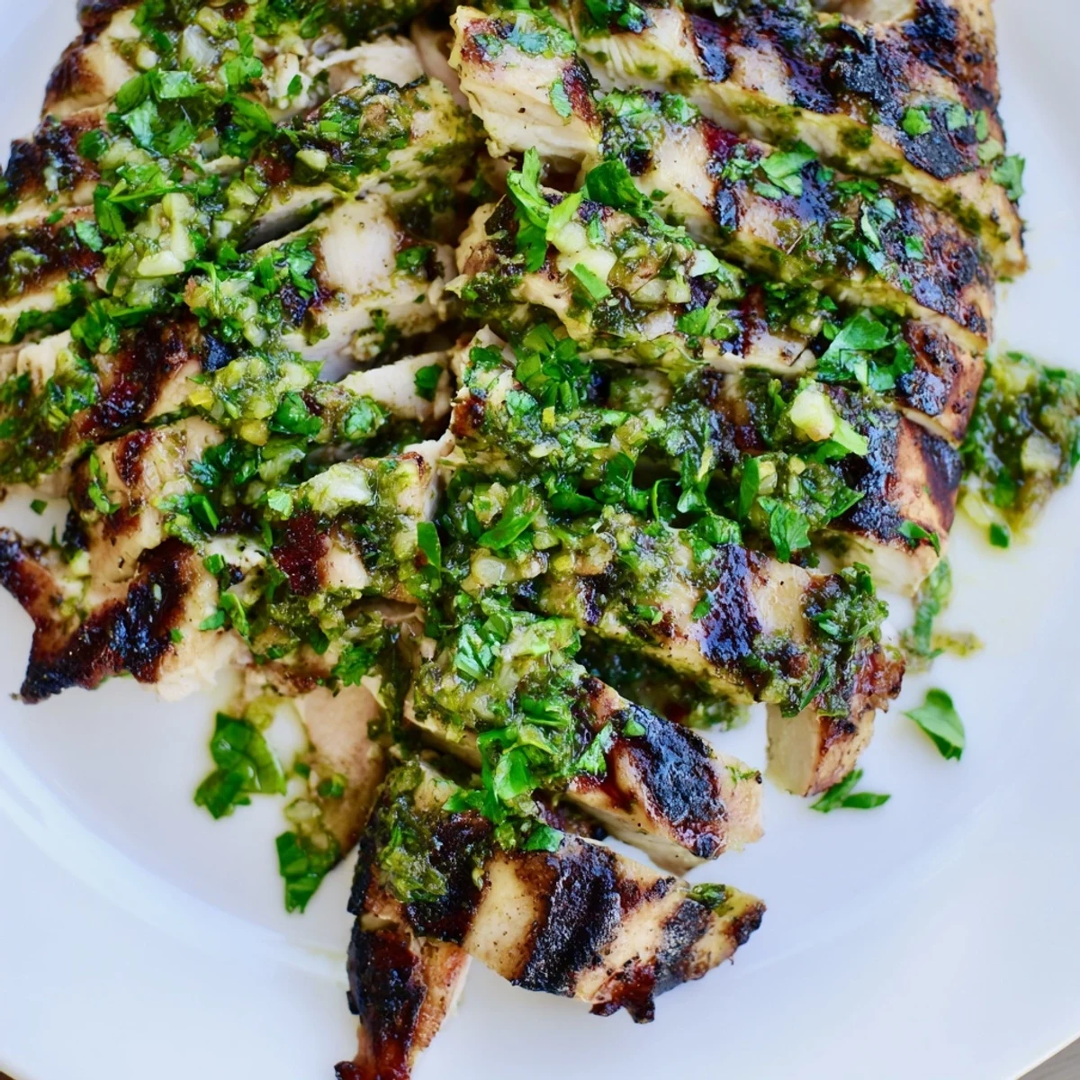 Juicy pan-seared cilantro lime chicken sliced perfectly on a white serving platter.  