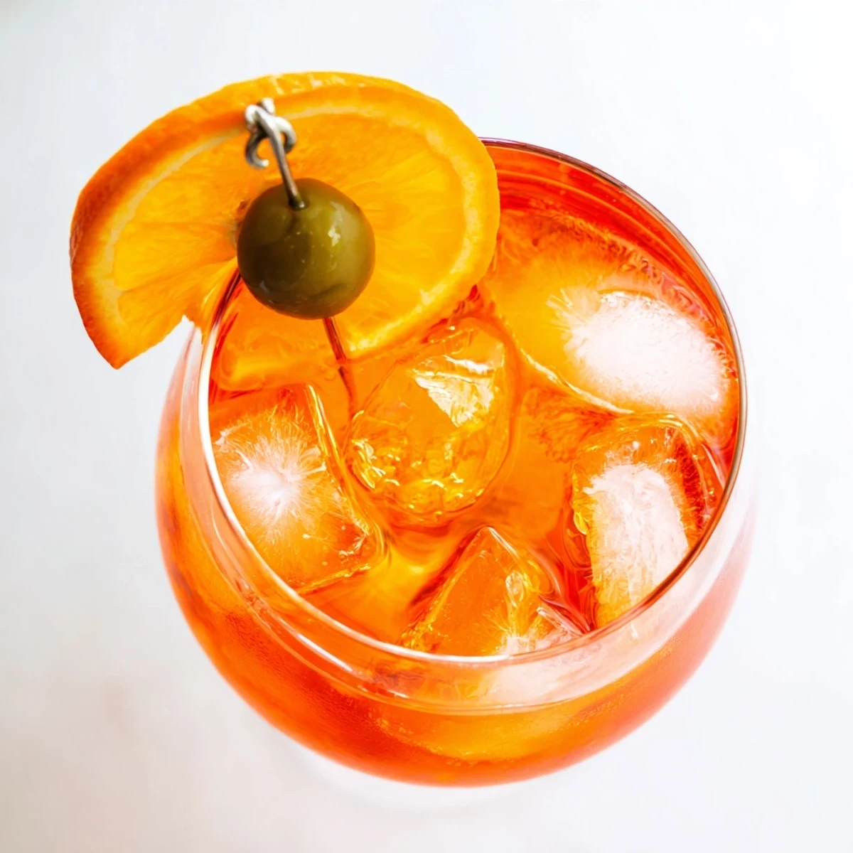 Refreshing Italian Spritz aperitif with orange slice and sparkling ice cubes.
