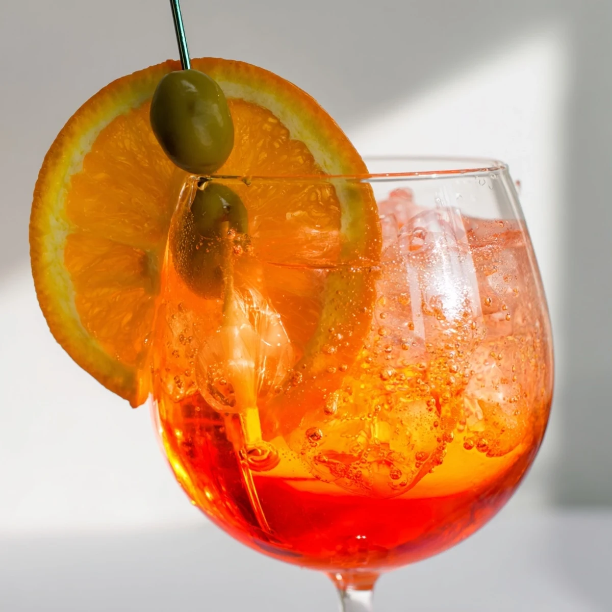 Bubbly Spritz recipe served in wine glass with olive garnish.  