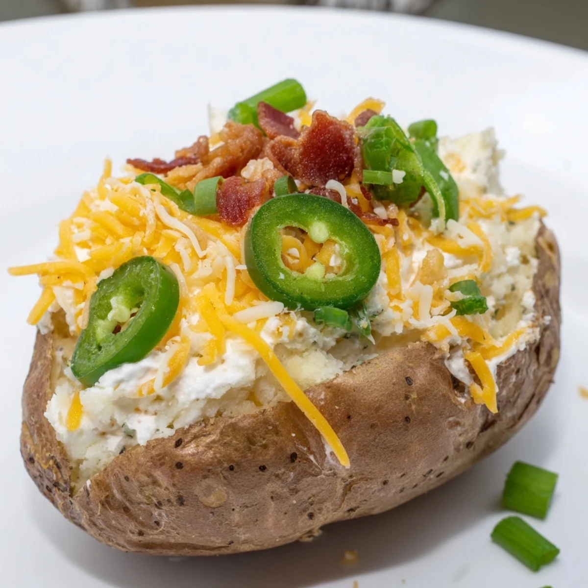 Golden Jalapeno Popper Twice Baked Potatoes topped with melted cheddar cheese and crispy bacon bits  