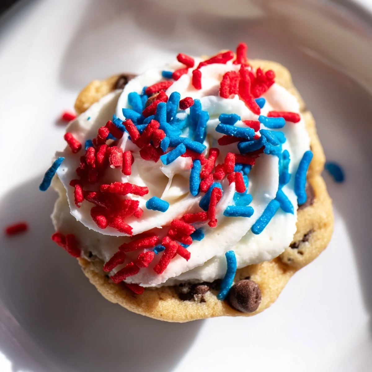 Festive patriotic chocolate chip cookie cups topped with red, white, and blue frosting.  