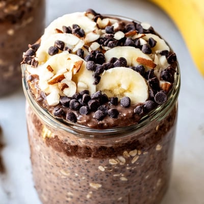 The Ultimate Healthy Chocolate Overnight Oats in mason jars with chocolate chips and fresh berries, a healthy breakfast.