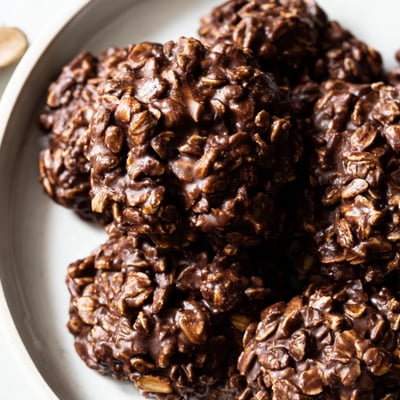 Fudgy chocolate oatmeal no bake cookies studded with oats on a rustic plate