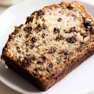 Golden slice of one bowl banana bread studded with melted chocolate chips.  