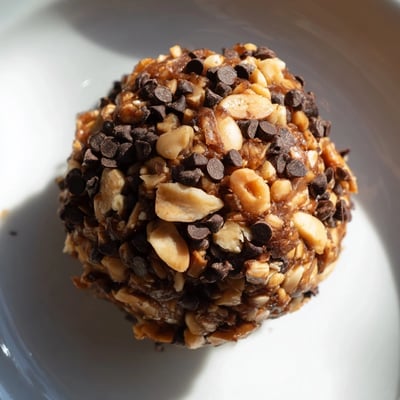 No-bake Snickers energy bites featuring rich cocoa, creamy peanut butter, and crunchy roasted peanuts for a healthy snack.  